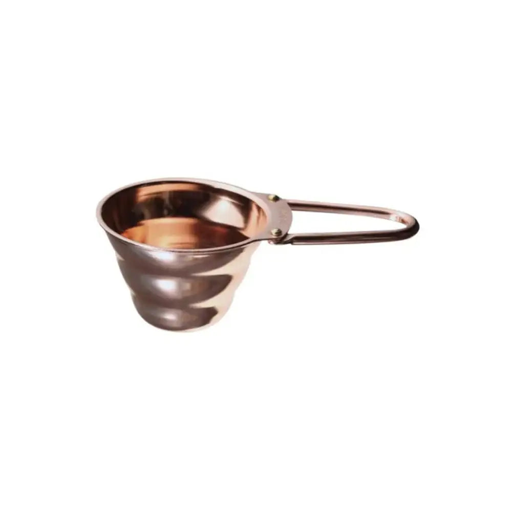 Copper-colored measuring spoon with handle on a white background