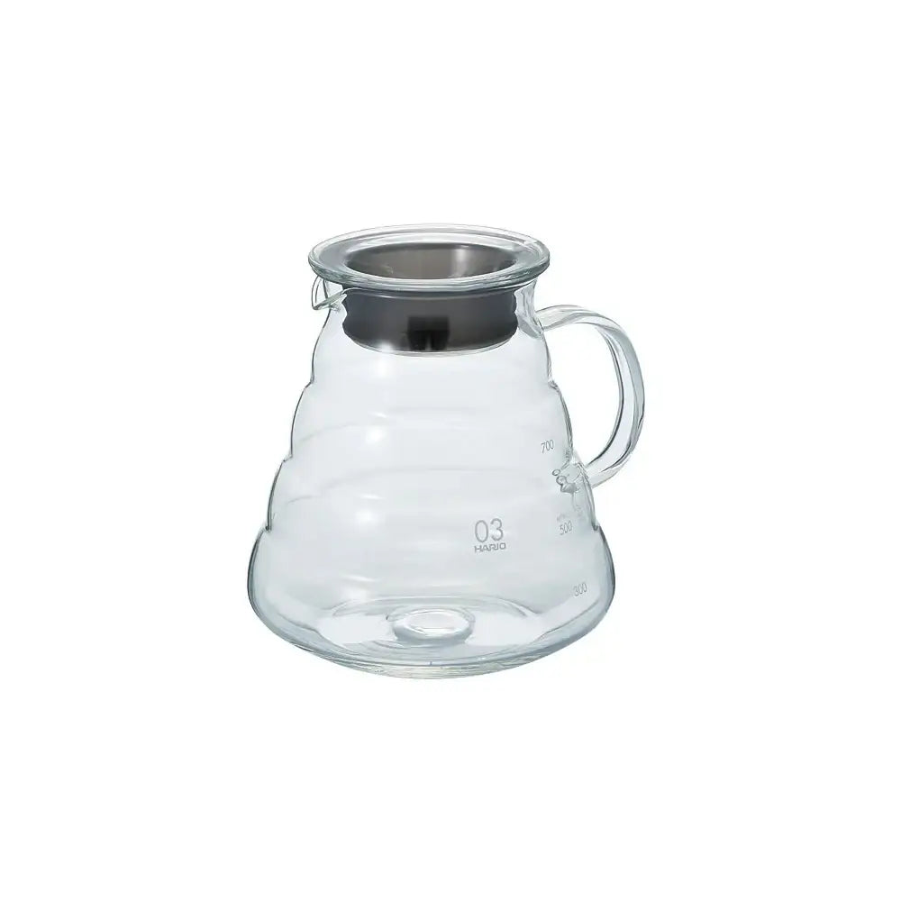 Clear glass coffee server with metal lid on a white background
