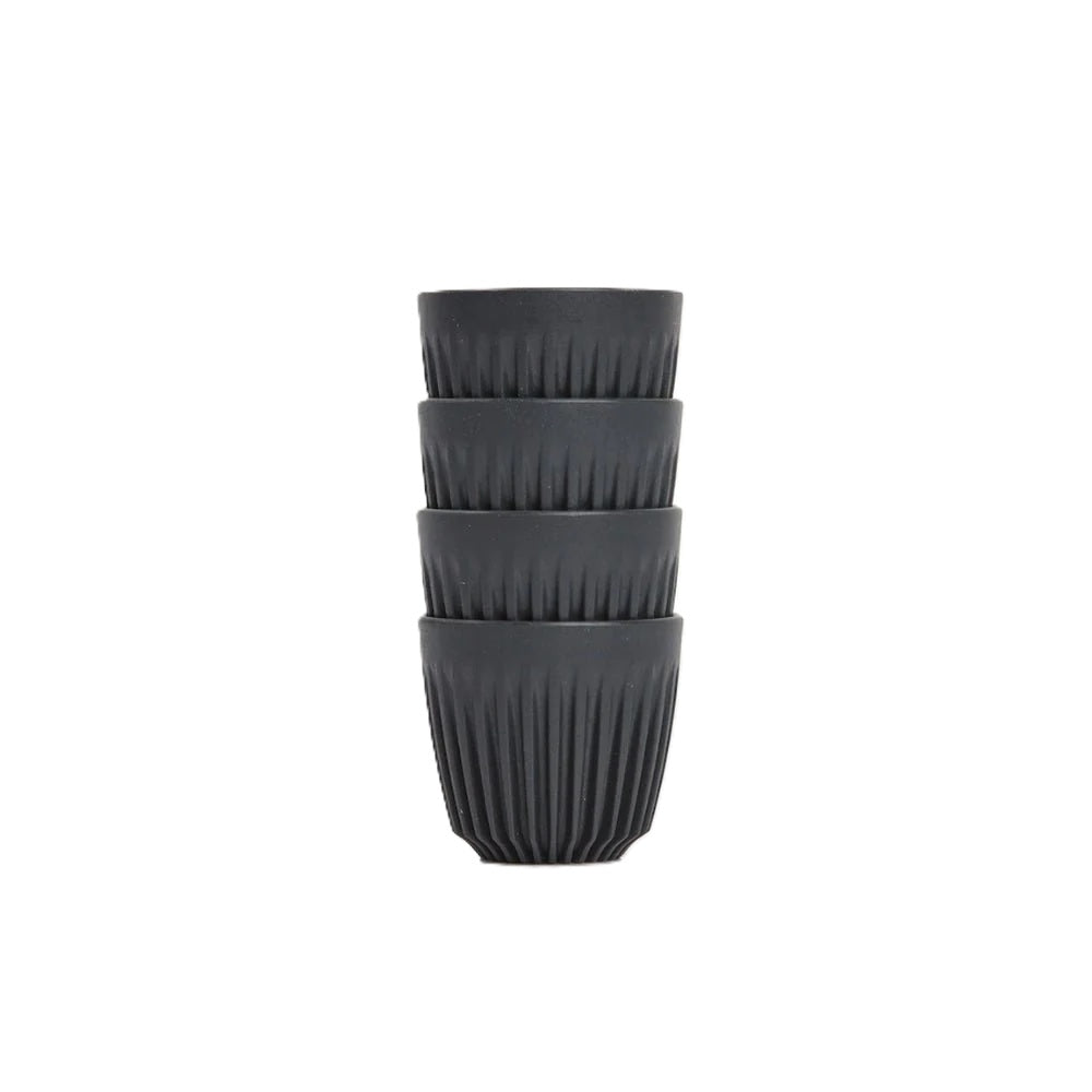 Set of four black ribbed cups stacked on a white background