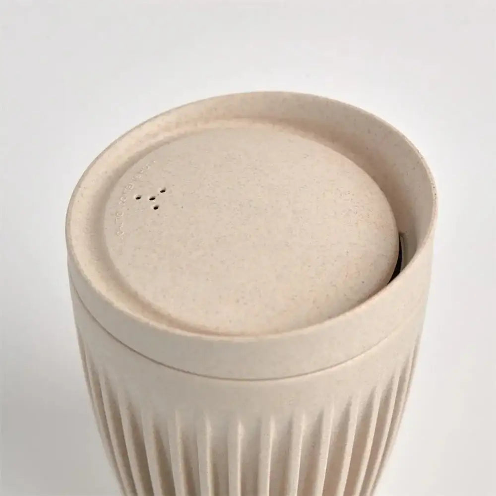 Beige ceramic container with a lid on a white background