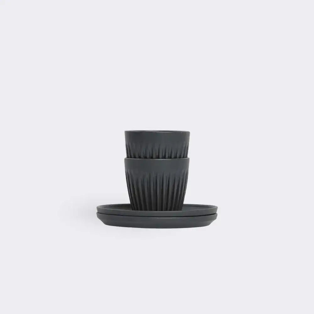 Set of black espress cups and saucers on a white background
