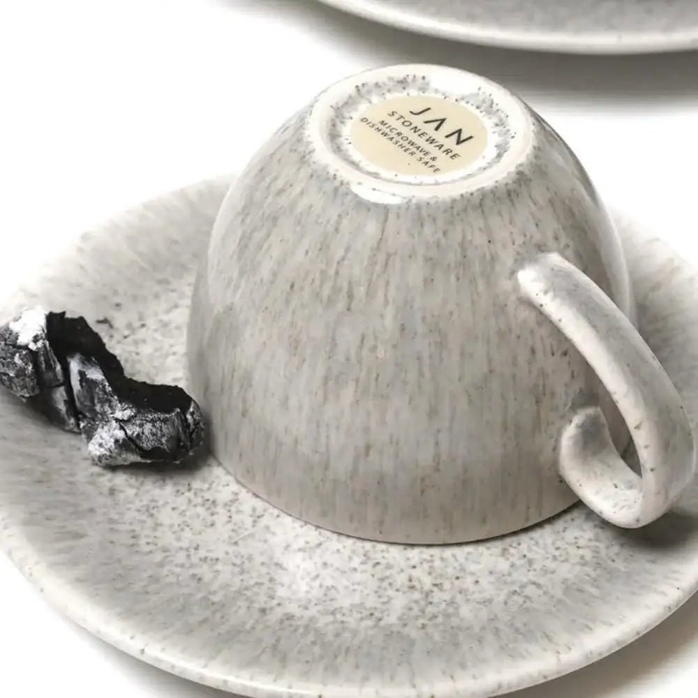 Ceramic cup and saucer with a textured finish on a white background