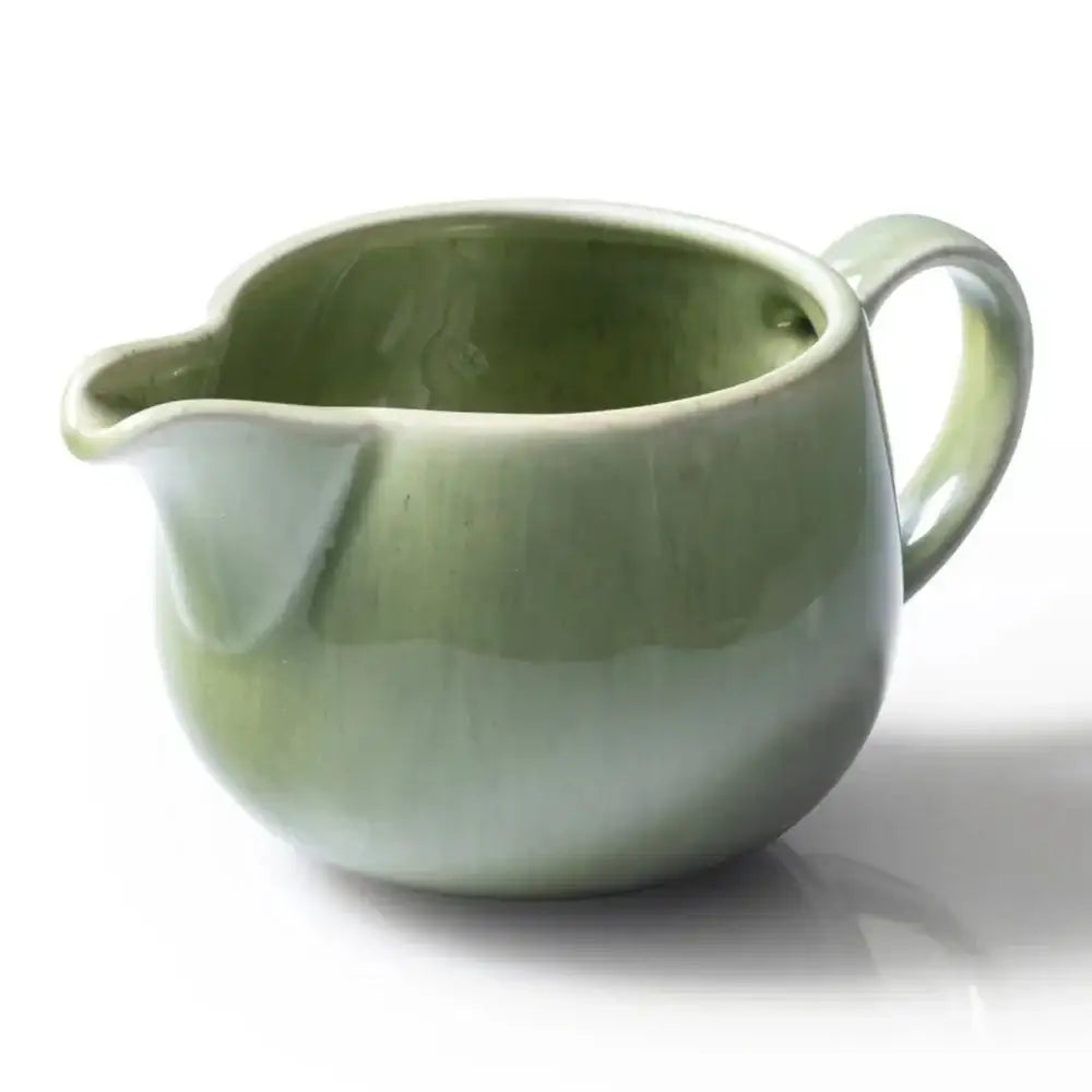 Green ceramic pitcher on a white background
