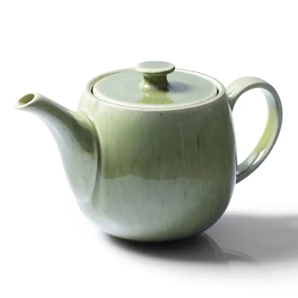 Green ceramic teapot on a white background