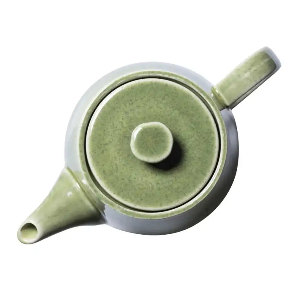 Green ceramic teapot with lid on a white background