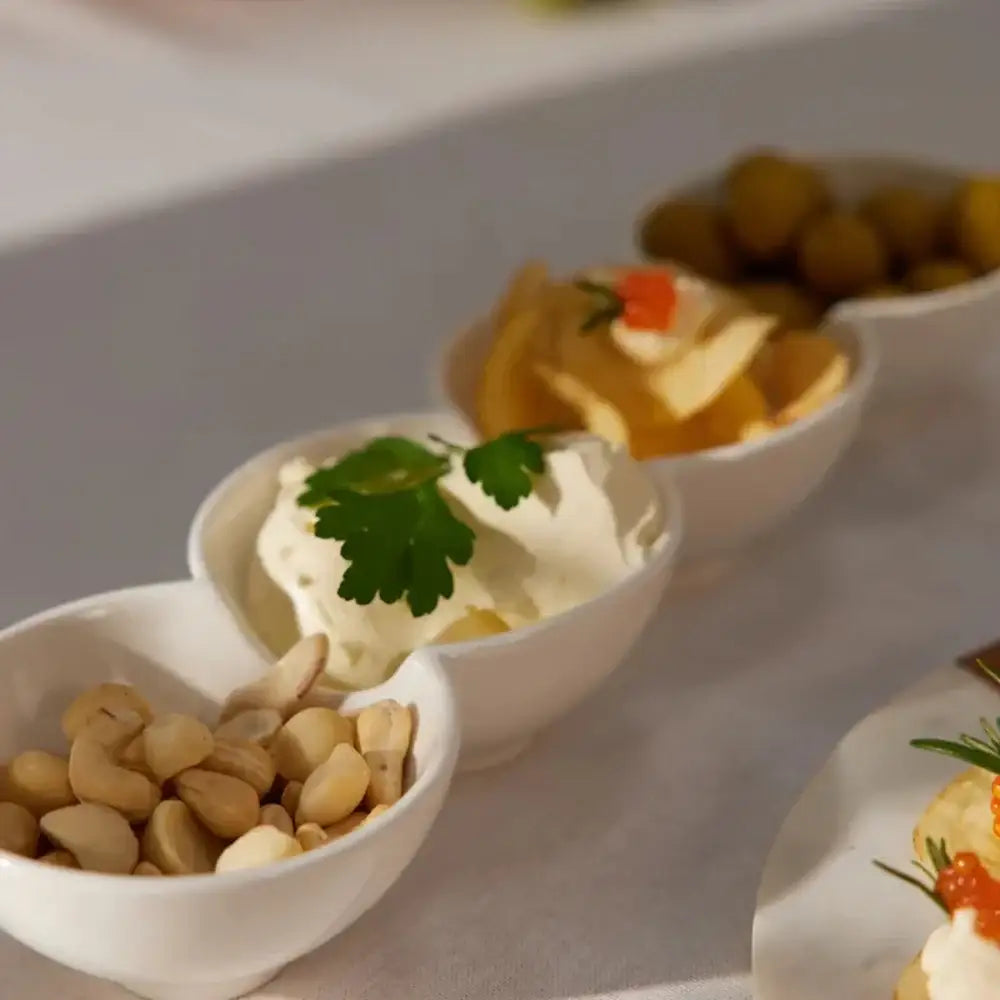 Assorted small dishes with appetizers on a white surface