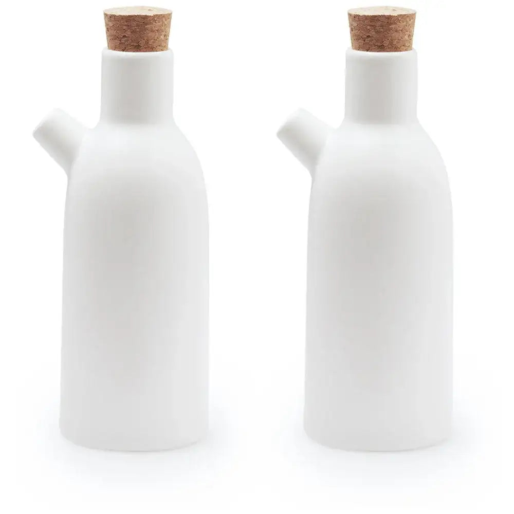 Two white ceramic bottles with cork lids on a white background