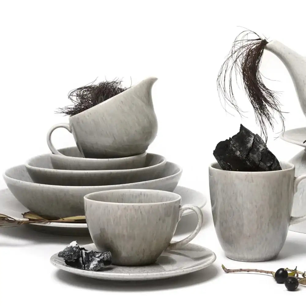 Set of gray ceramic tea cups and saucers on a white background