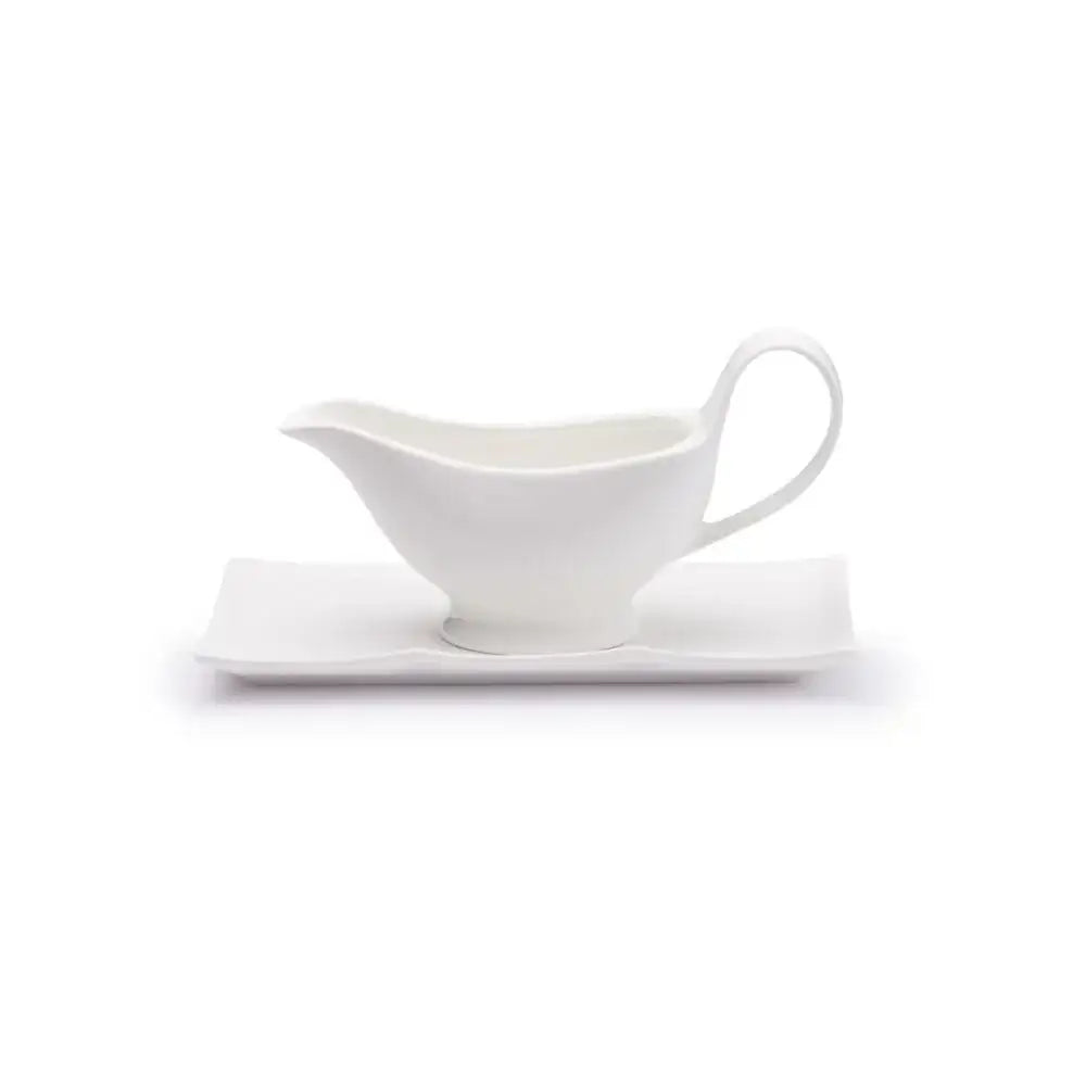 White gravy boat on a white plate with a white background