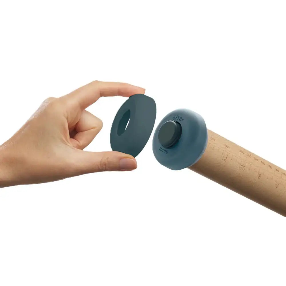 Hand holding two blue silicone bushings against a white background