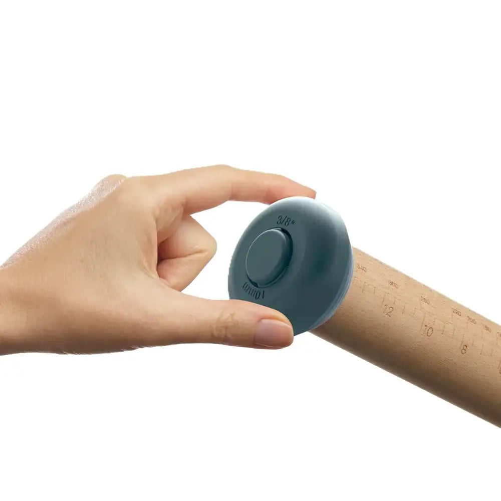 Hand holding a small blue device against a white background