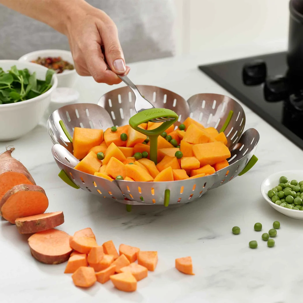 Person using a stainless steel steamer basket 