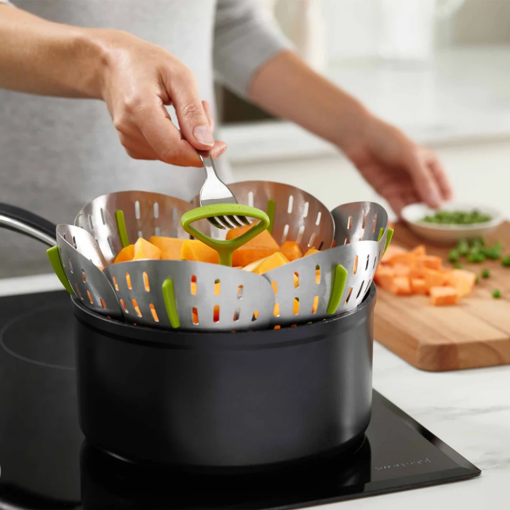 Person using a steamer basket inside a pot 