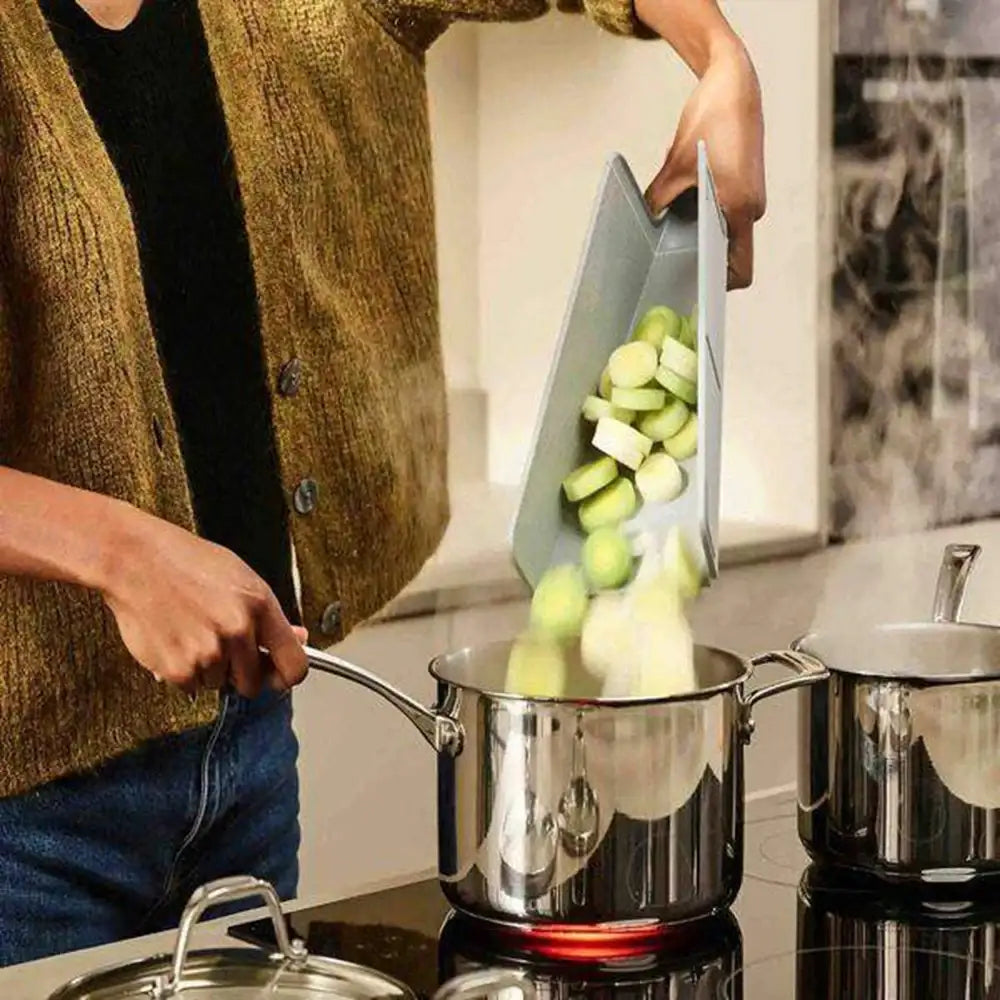 Person using a kitchen tool to chop vegetables over a pot on a stove.