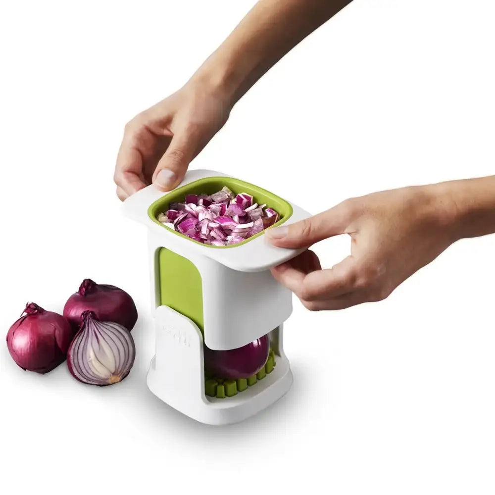 Person using a vegetable chopper with red onions on a white background