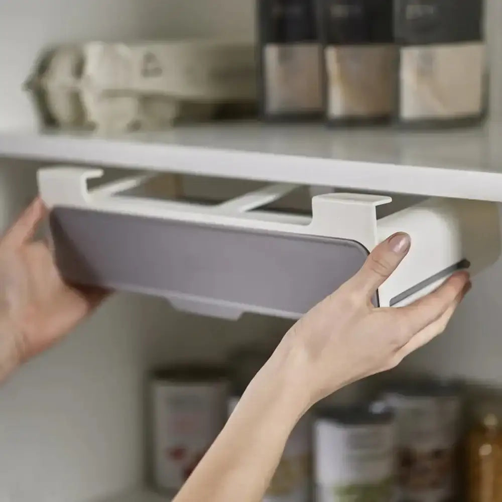 Person using a kitchen cabinet organizer with shelves in the background