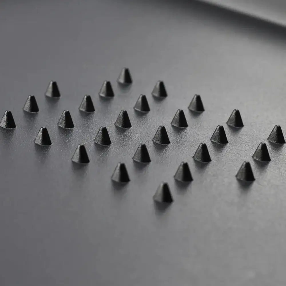 Black pyramid-shaped objects arranged in a pattern on a dark surface
