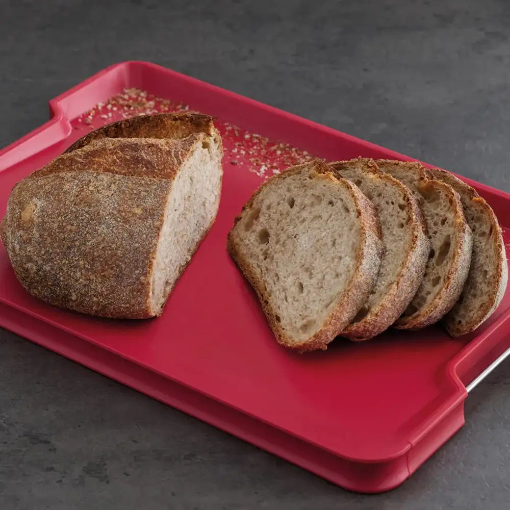 Sliced bread on a red cutting board with a dark background