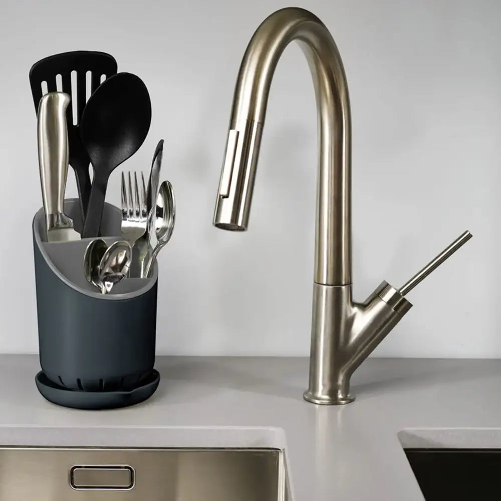 Modern kitchen sink with faucet and utensil holder on a countertop