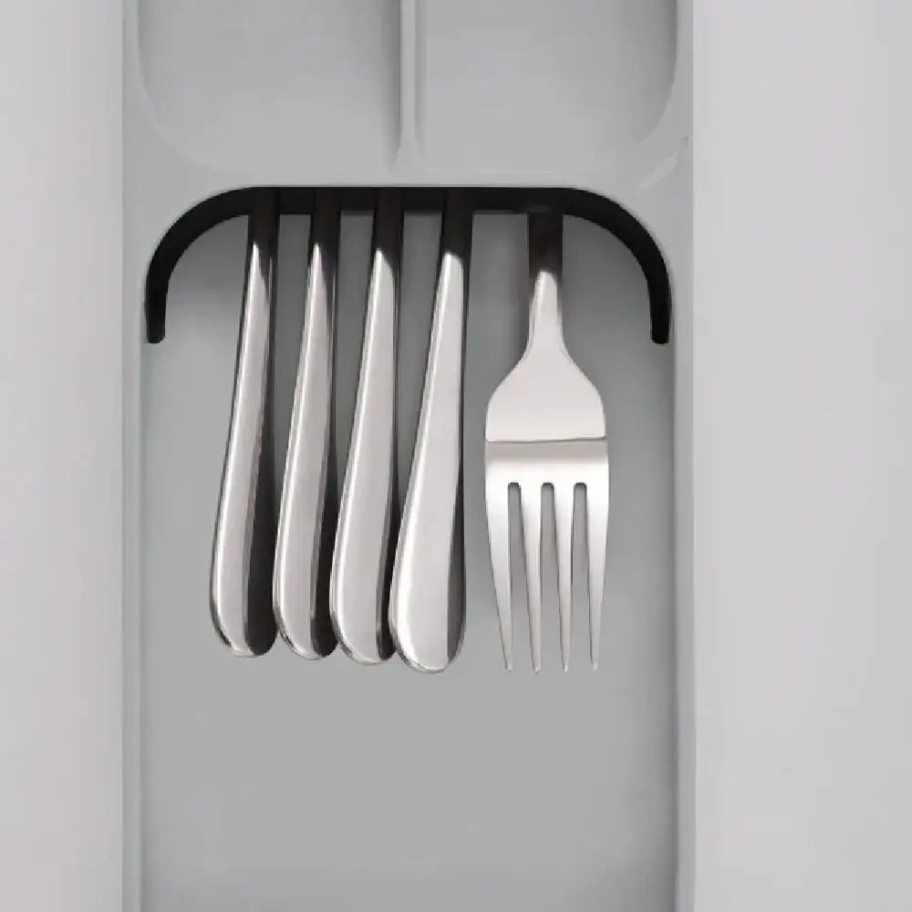 Grey cutlery organizer drawer with metal forks neatly arranged in compact slots