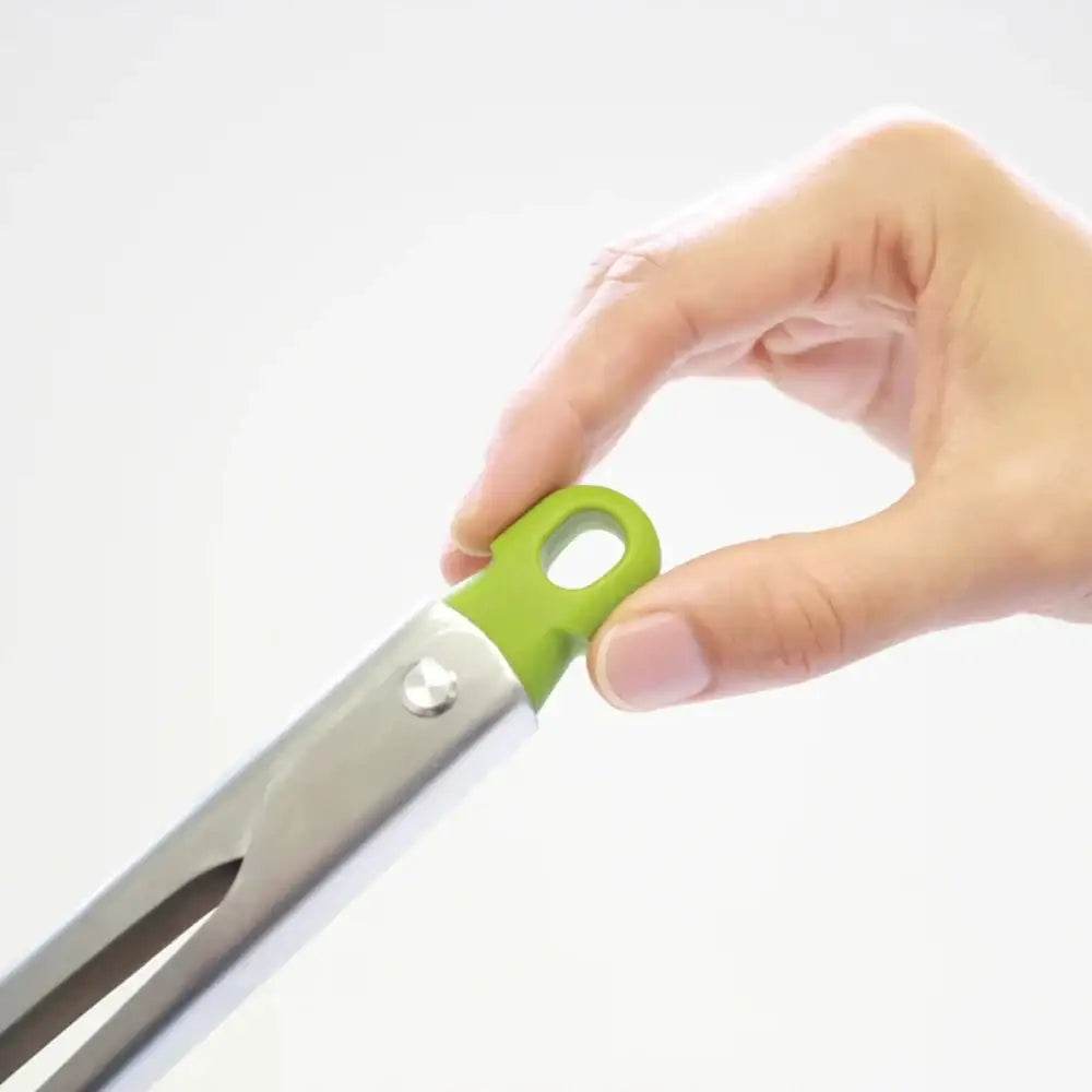 Hand holding tongs with a green handle on a white background
