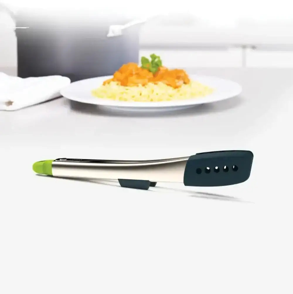 Set of tongs with a plate of food in the background