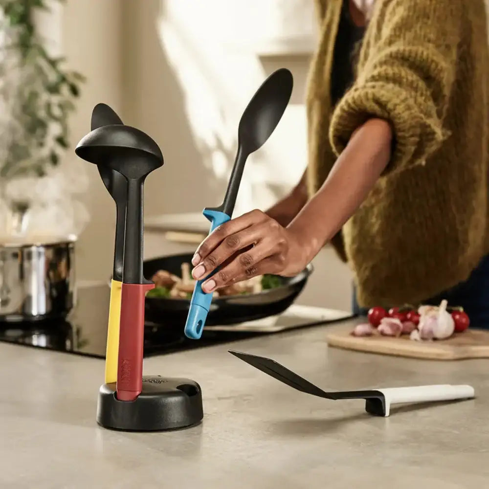 Kitchen utensils including a ladle, spoon, and spatula in a stand on a kitchen counter.