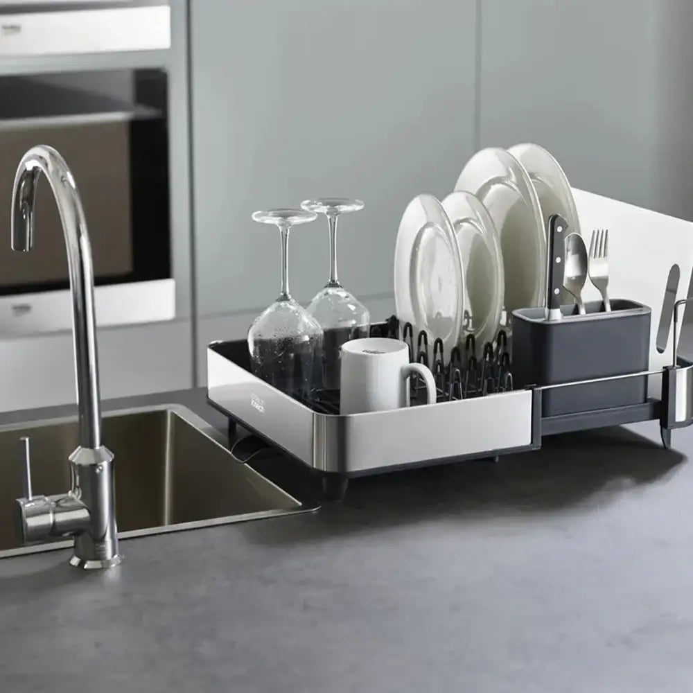 Dish rack with dishes next to a kitchen sink