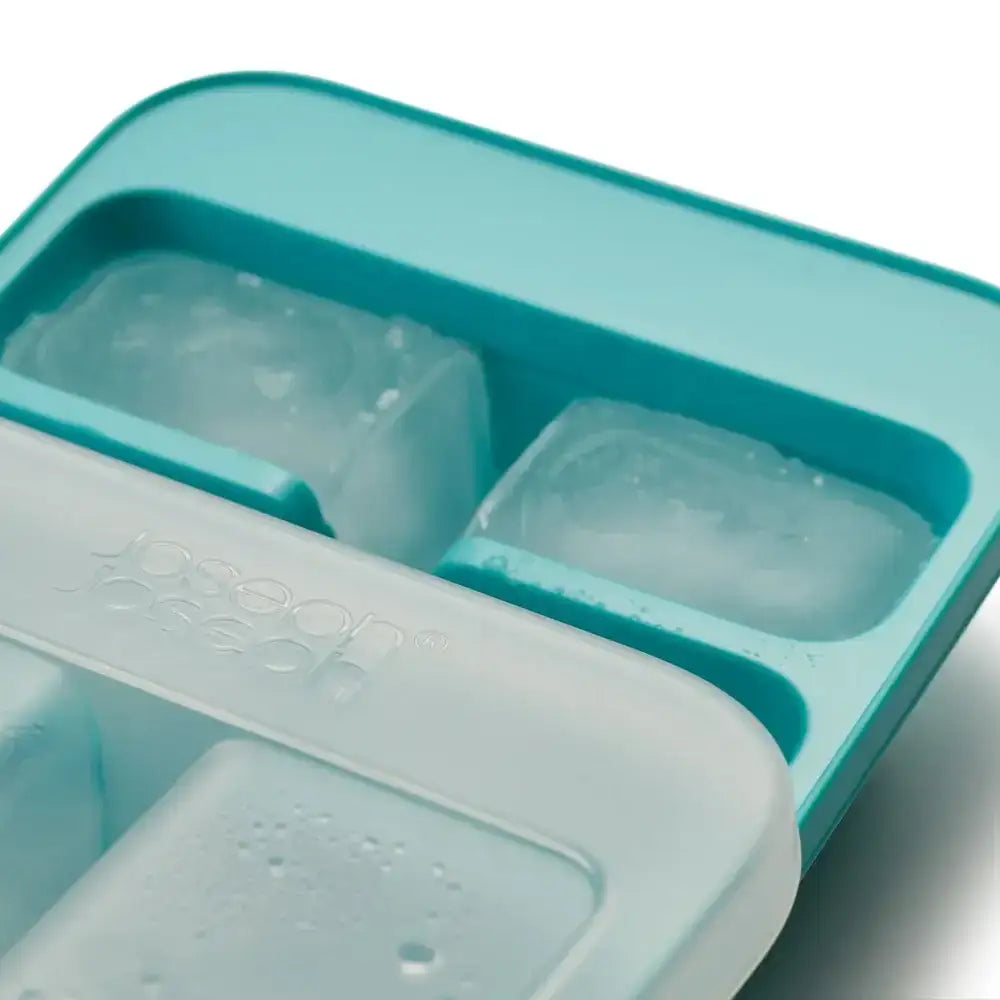 Teal silicone ice cube tray with partially filled ice cubes on a white background