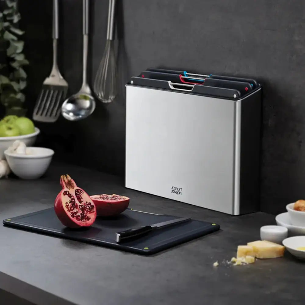 Knife sharpener on a kitchen counter with cutting board and pomegranate