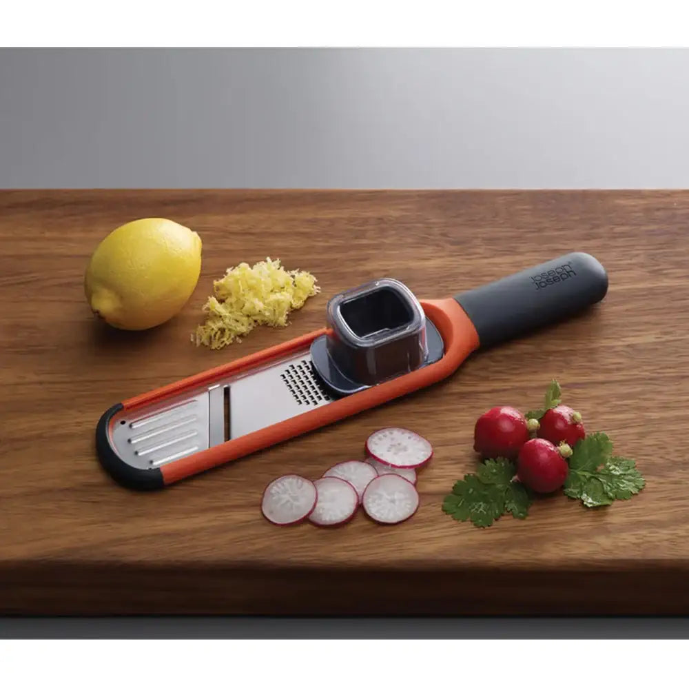 Vegetable peeler on a wooden surface with sliced radishes, lemon, and ginger.