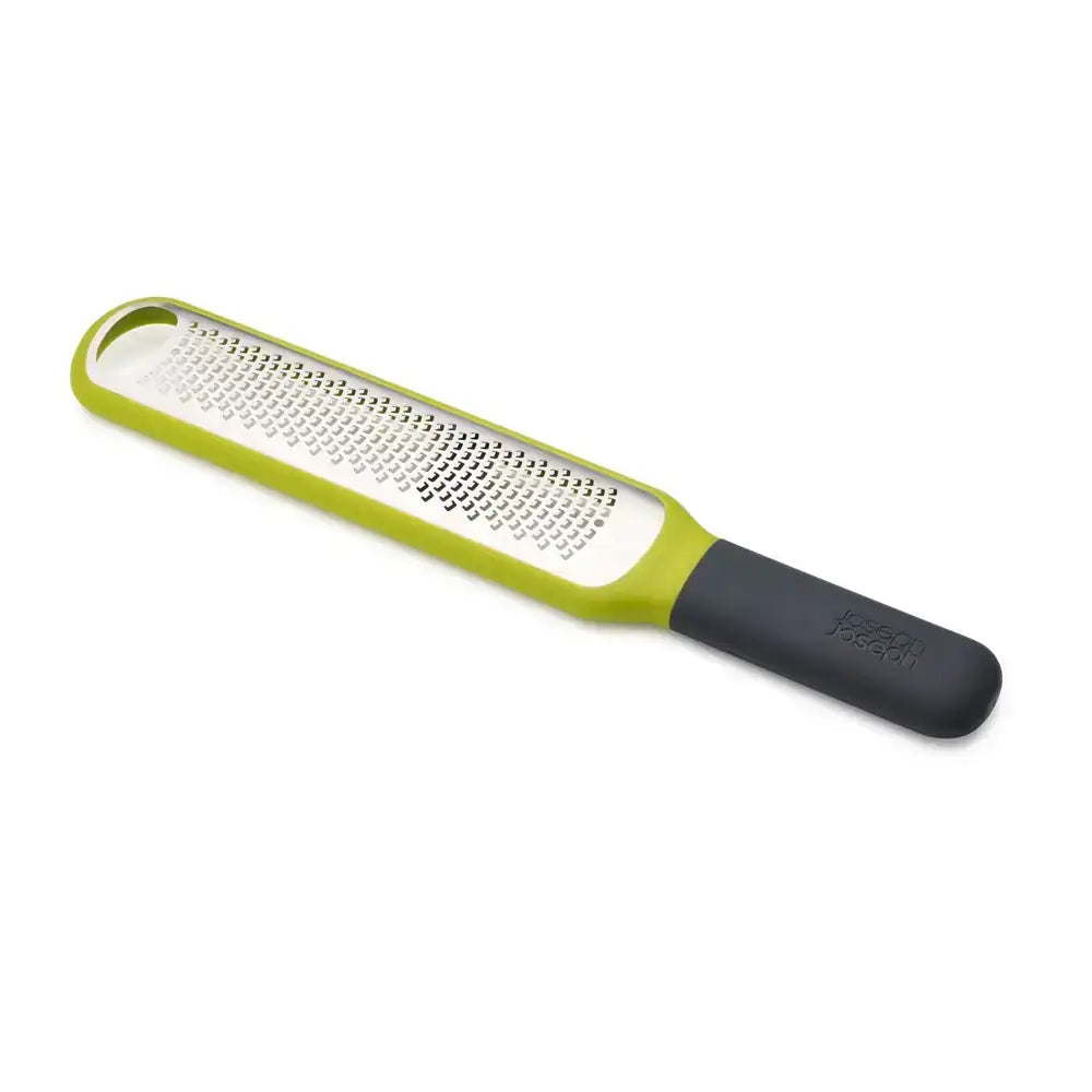 Green and black handheld grater on a white background