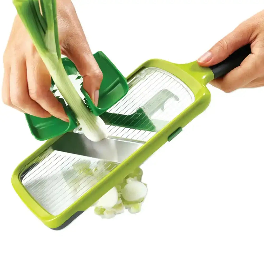 Green vegetable slicer being used to slice a celery stalk on a white background