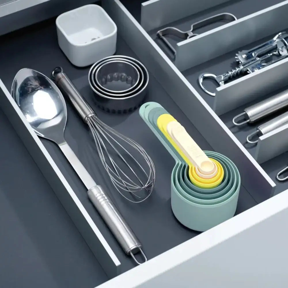 Open kitchen drawer with utensils and measuring cups