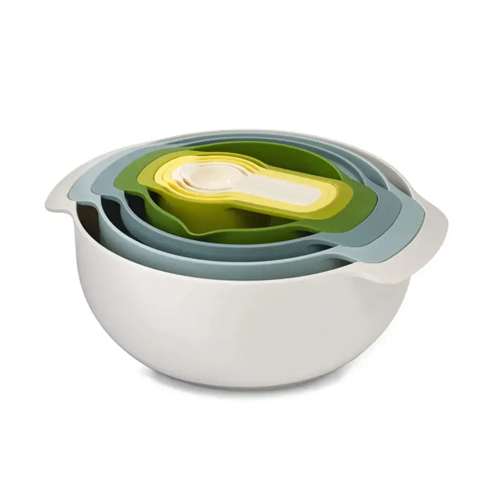 Set of nested bowls in green, white, and gray on a white background