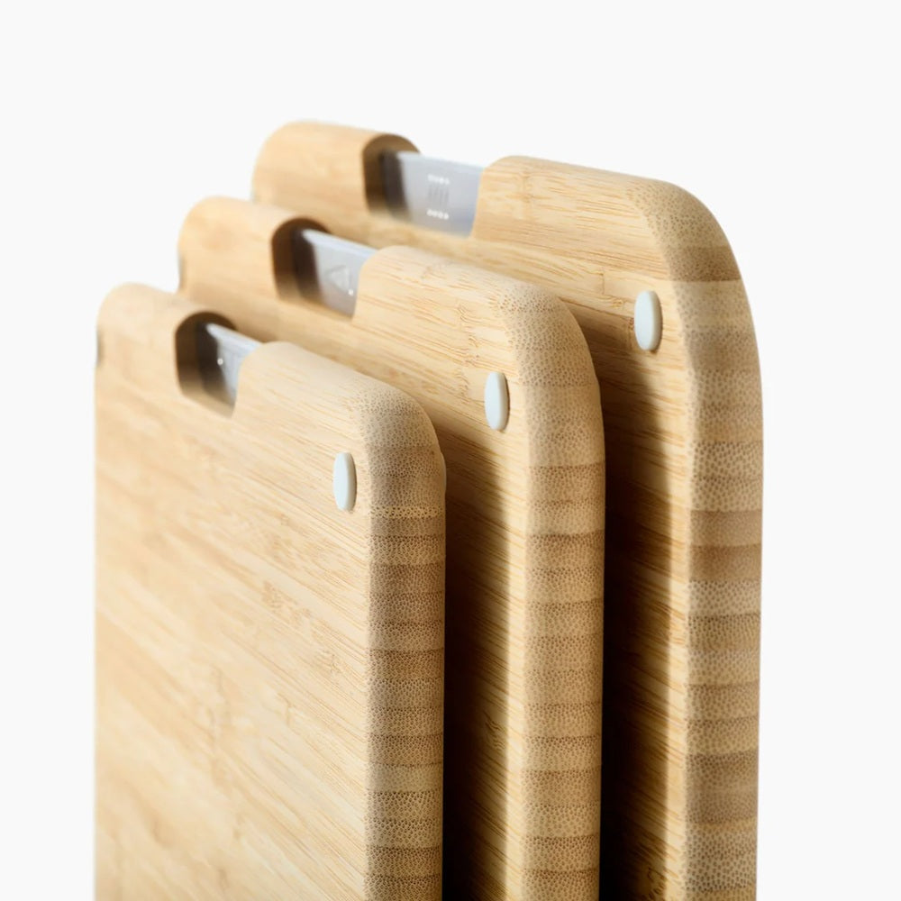 Set of three wooden cutting boards with handles on a white background