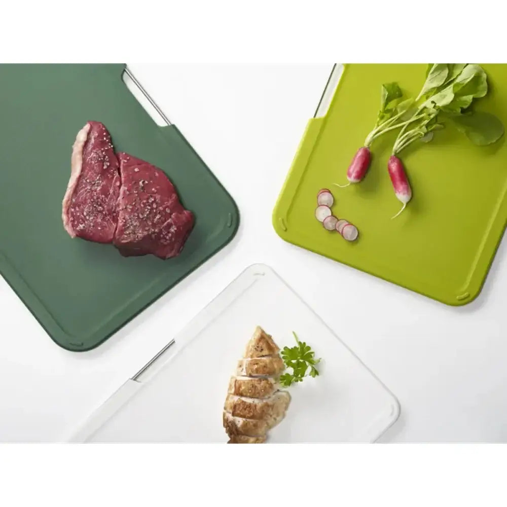 Three cutting boards with different food items on a white background