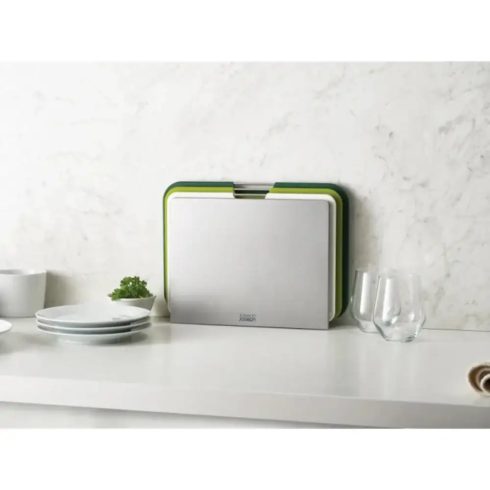 Rectangular cutting board with green rim on a kitchen counter
