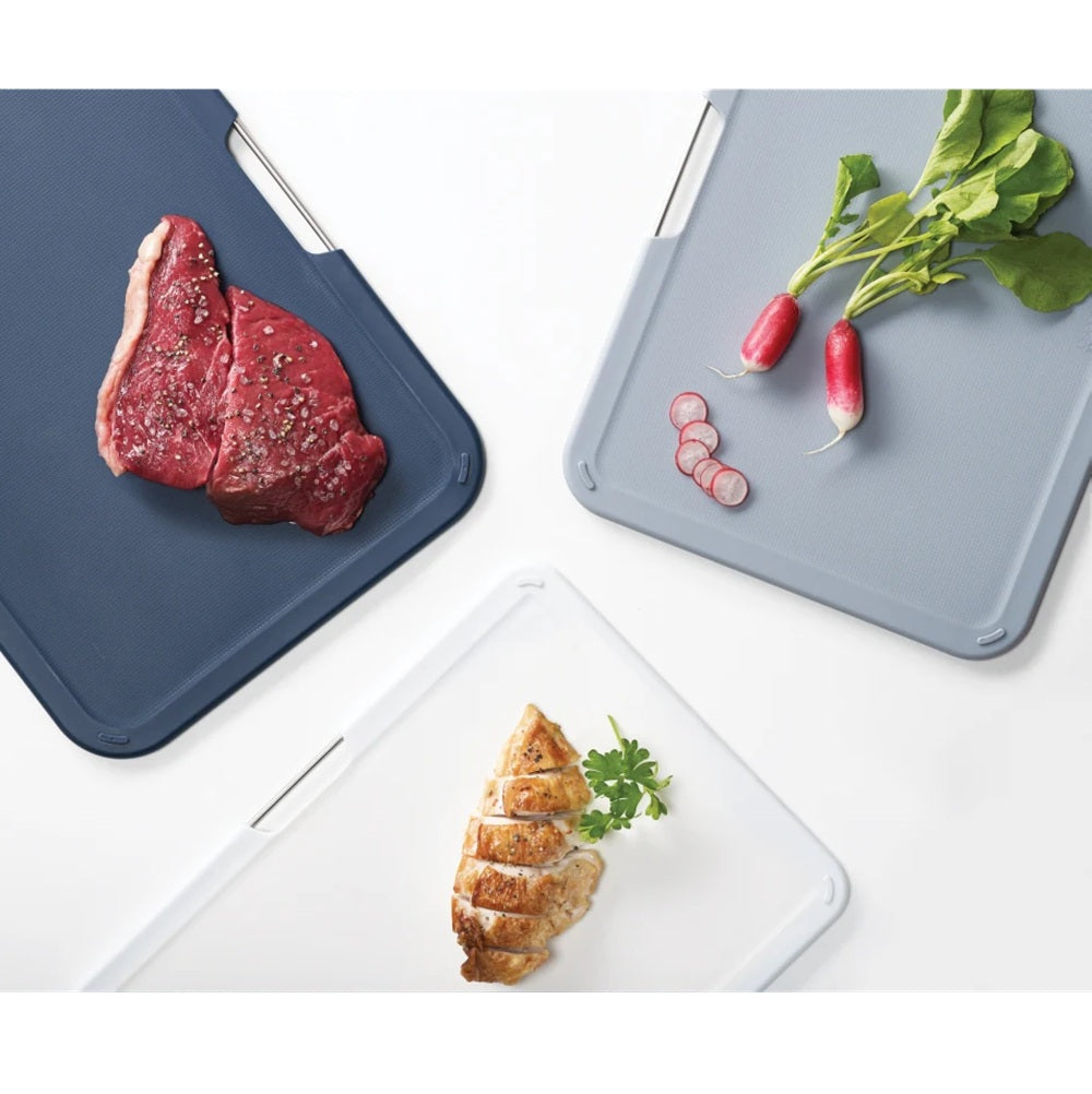 Three cutting boards with different food items on a white background