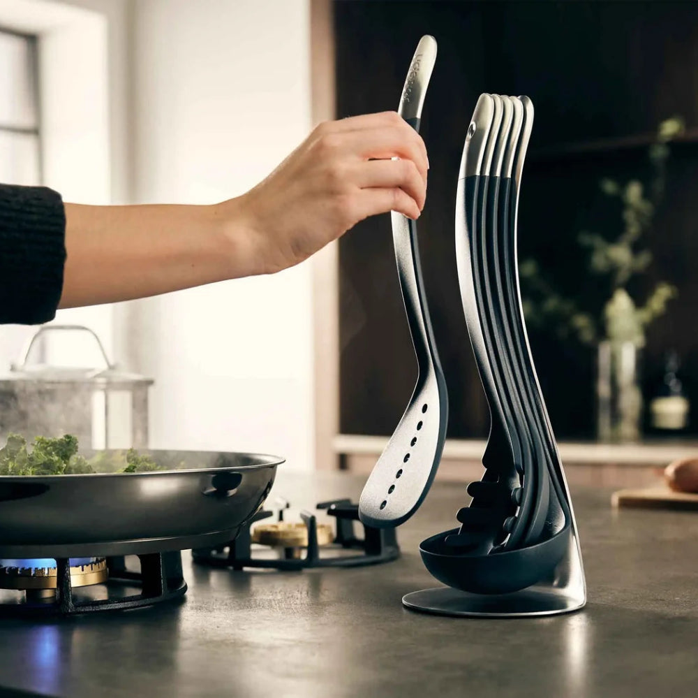 Person using a modern kitchen spatula set on a stove with a blurred kitchen background