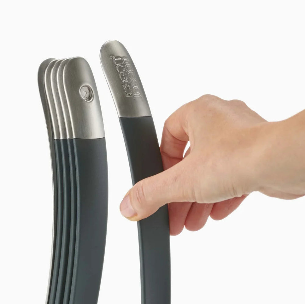 Hand holding a black and silver kitchen tool against a white background