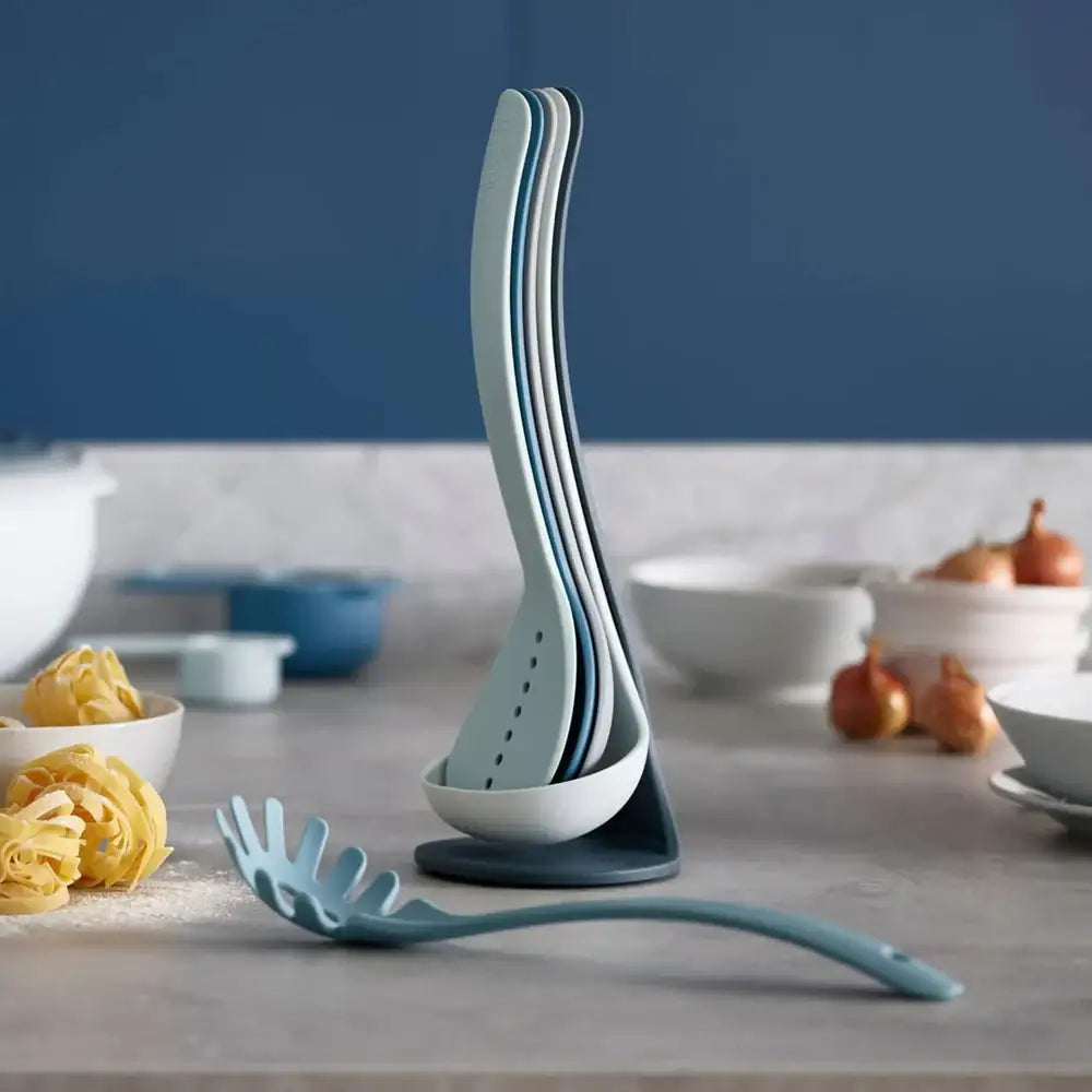 Set of blue kitchen utensils including ladles and a spoon on a countertop with a kitchen background.