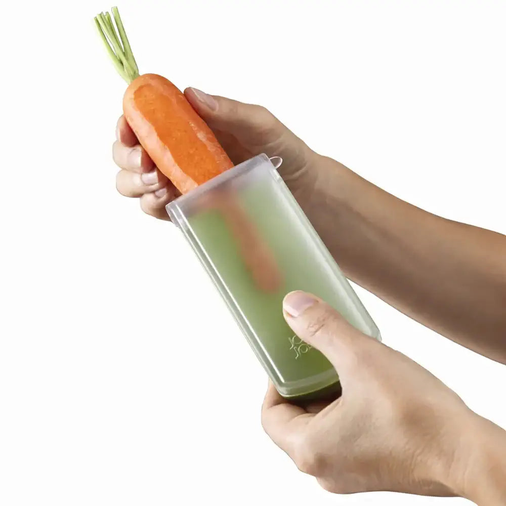 Person holding a transparent container with a carrot inside on a white background