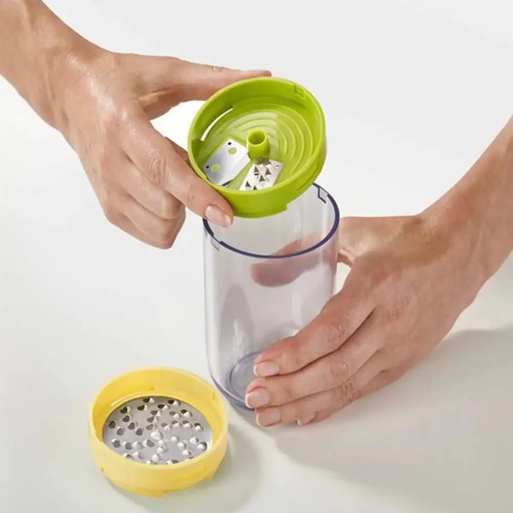 Person assembling a kitchen tool with a green top and yellow base on a white background