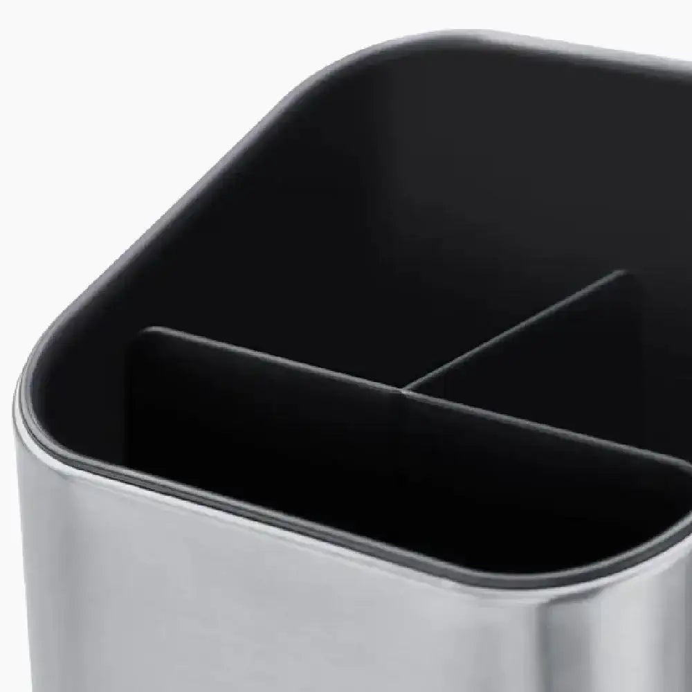 Close-up of a black trash bin with a metallic base