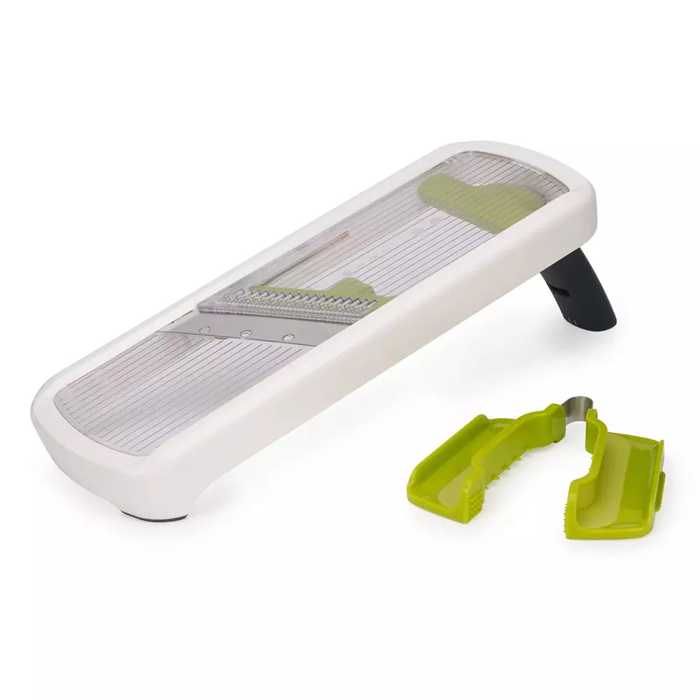 A white mandoline slicer with a clear protective cover, silver metal blades, and lime green accessory guards, shown on a clean white background.