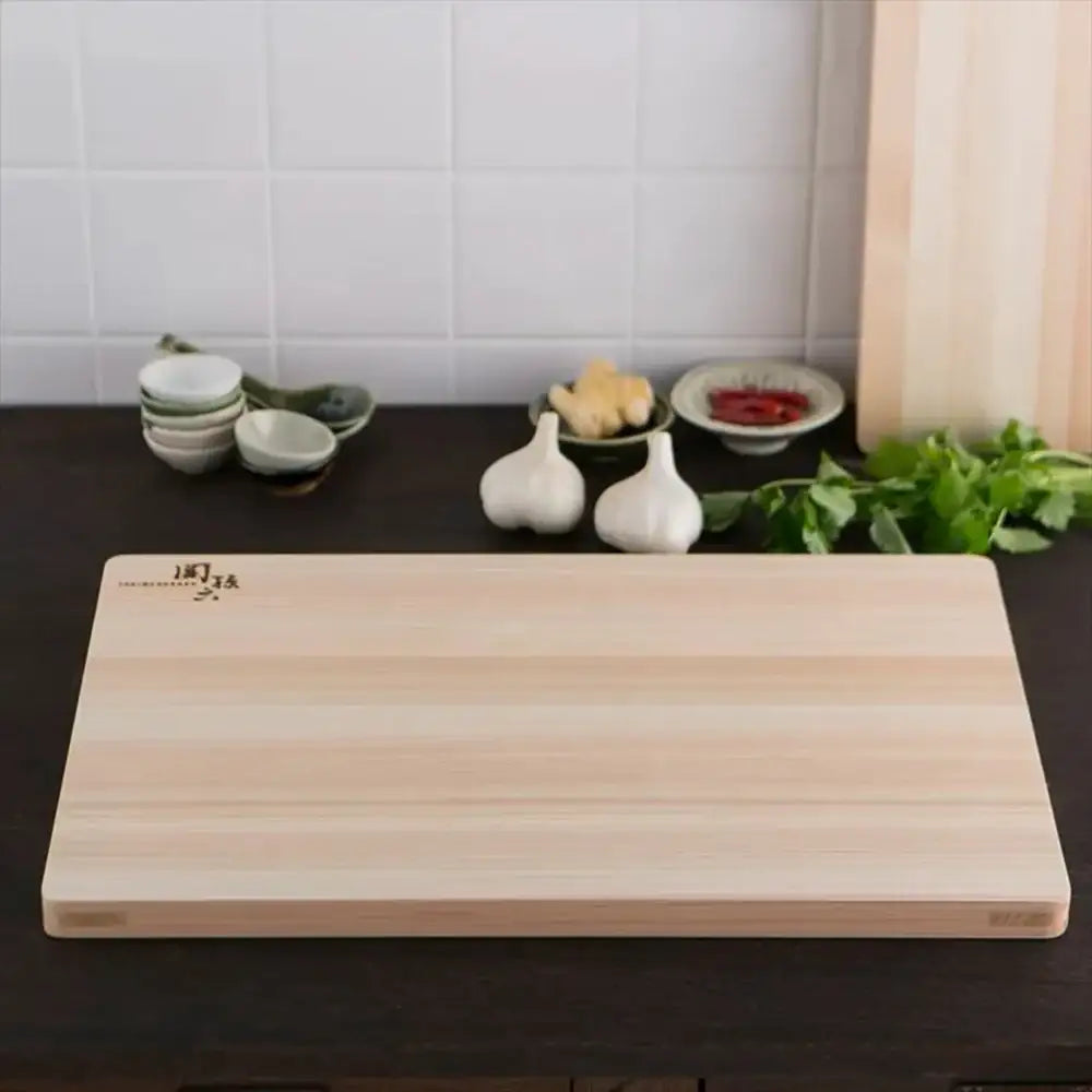 Wooden cutting board on a kitchen counter with various kitchen items in the background.