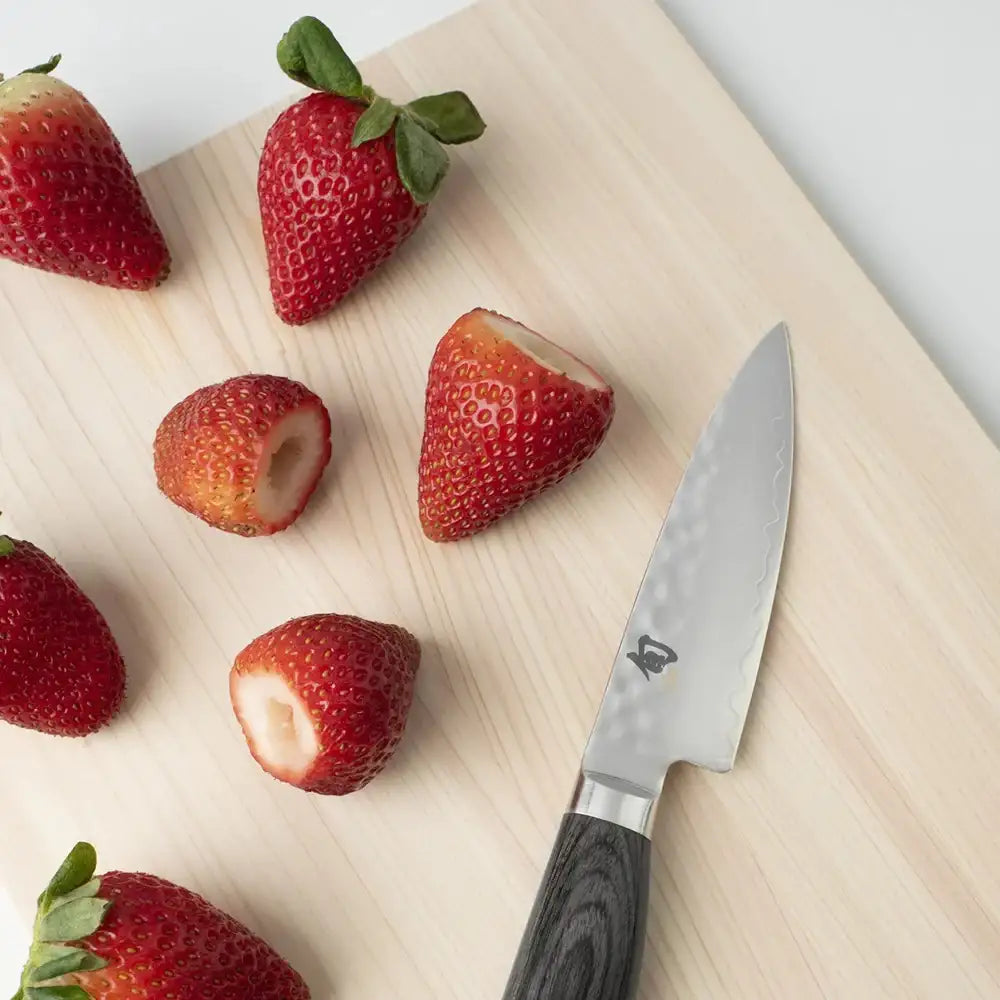 Strawberries on a cutting board with a knife