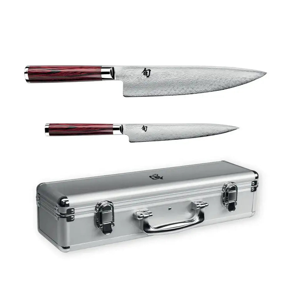 Two chef's knives with red handles and a silver case on a white background