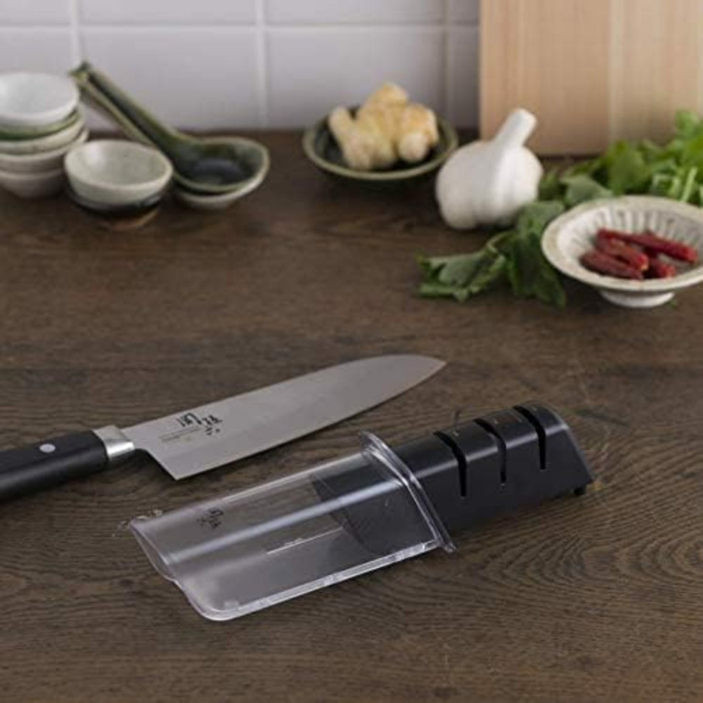 Knife sharpener on a wooden surface with a kitchen setting in the background